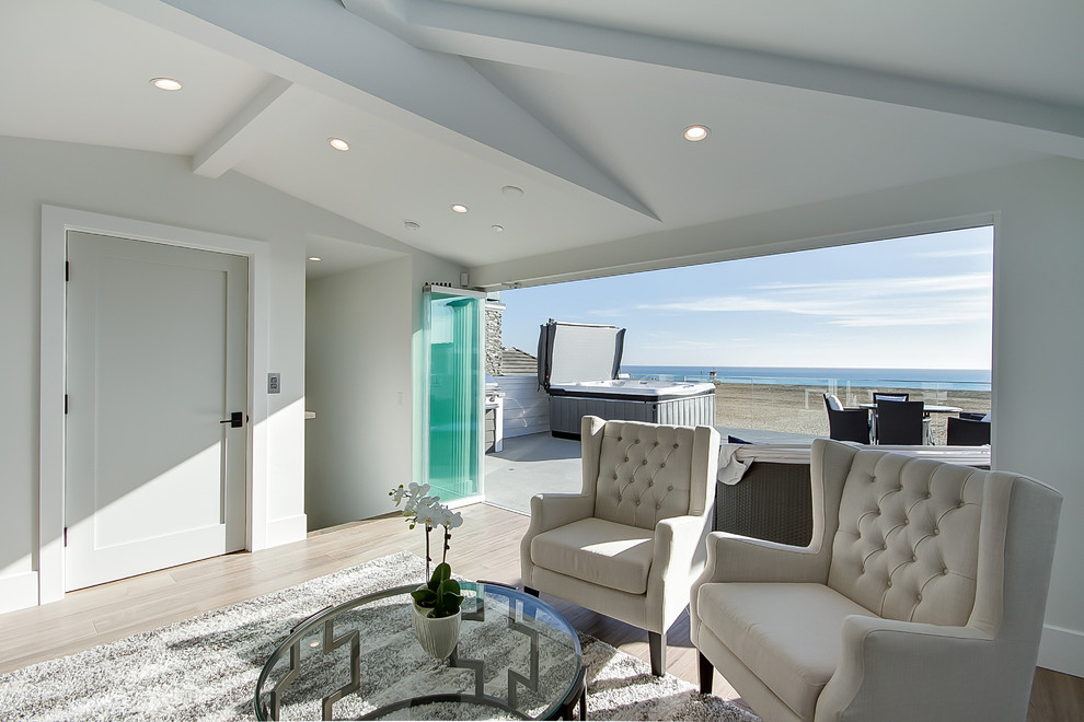 На фото: открытая гостиная комната в морском стиле с серыми стенами, полом из керамогранита и коричневым полом без камина, телевизора с