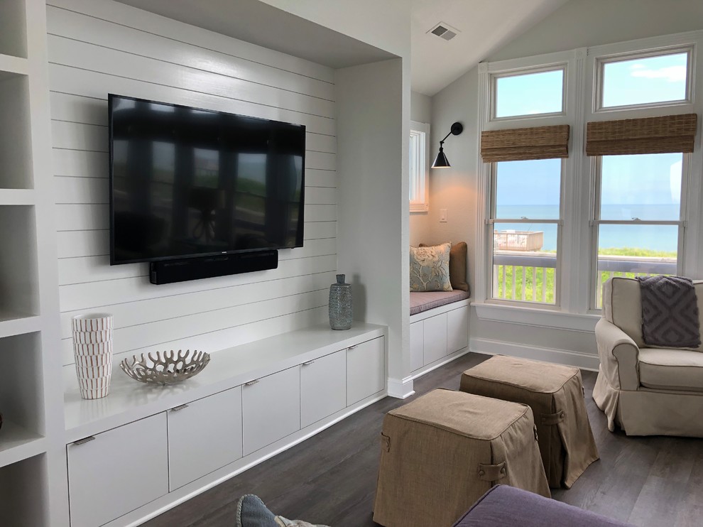 Großes, Abgetrenntes Maritimes Wohnzimmer ohne Kamin mit grauer Wandfarbe, braunem Holzboden, TV-Wand und grauem Boden in Sonstige