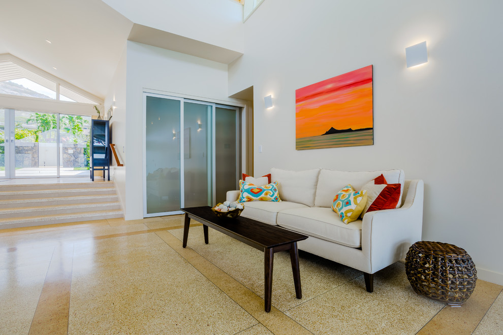 Foto de sala de estar abierta costera de tamaño medio con paredes blancas, suelo de cemento y suelo beige