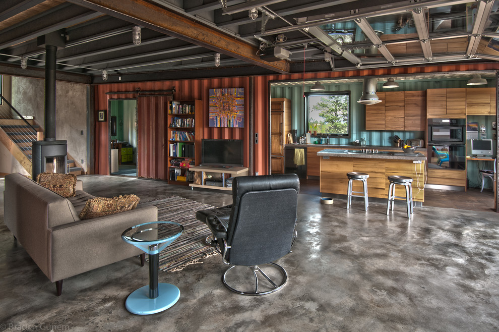 Diseño de sala de estar abierta urbana de tamaño medio con paredes rojas, suelo de cemento y televisor independiente