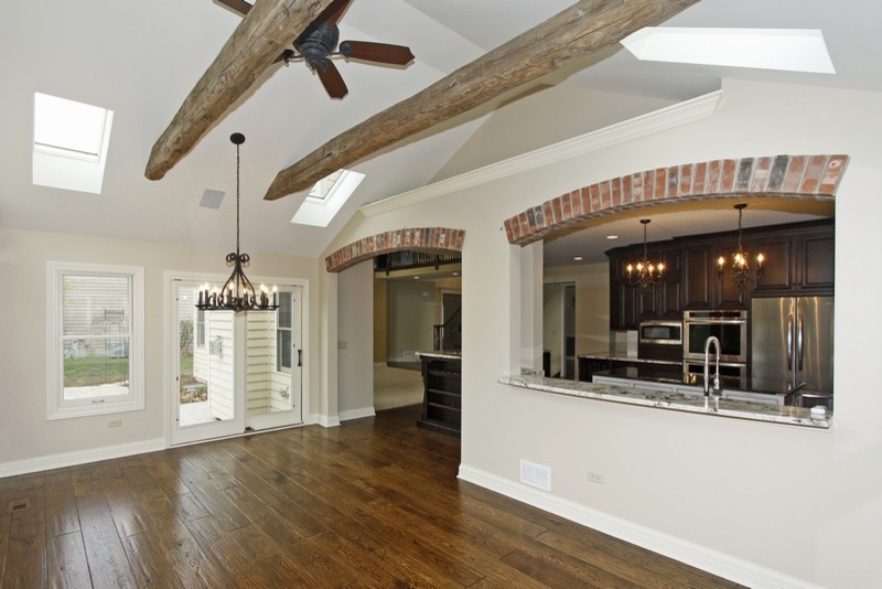 Foto de sala de estar abierta tradicional renovada grande sin chimenea con paredes beige y suelo de madera en tonos medios