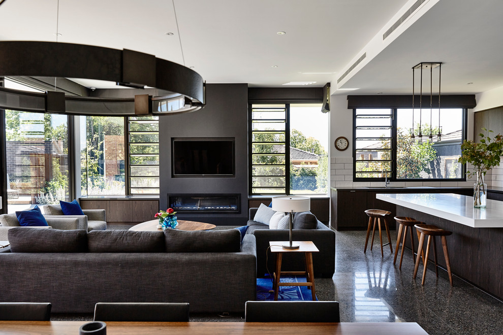 Expansive contemporary open plan games room in Melbourne with white walls, concrete flooring, a ribbon fireplace, a plastered fireplace surround and feature lighting.