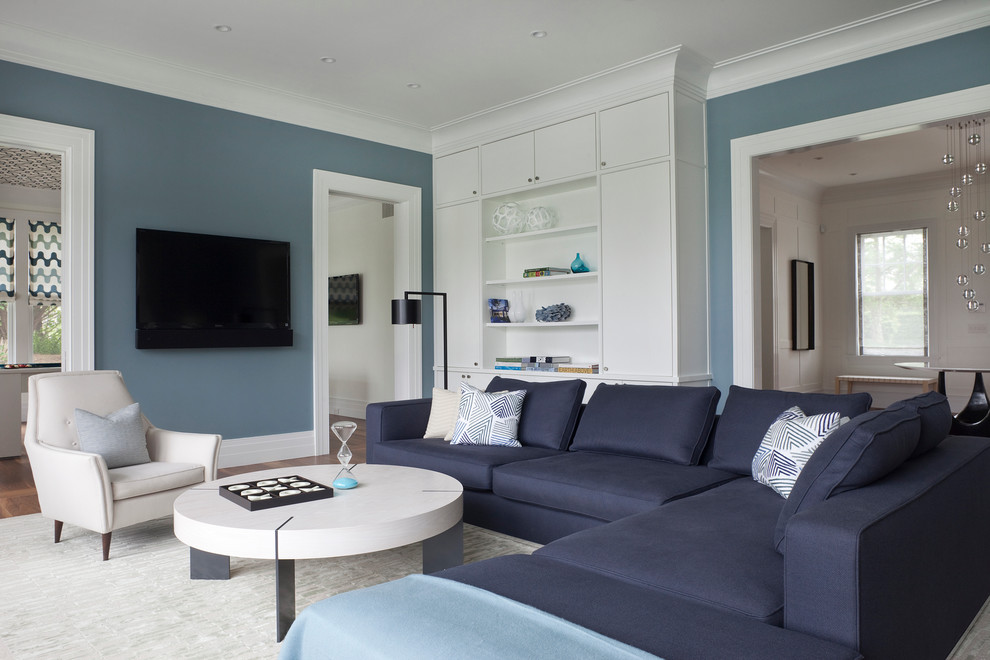 Свежая идея для дизайна: открытая гостиная комната среднего размера в современном стиле с синими стенами, паркетным полом среднего тона, телевизором на стене и коричневым полом без камина - отличное фото интерьера