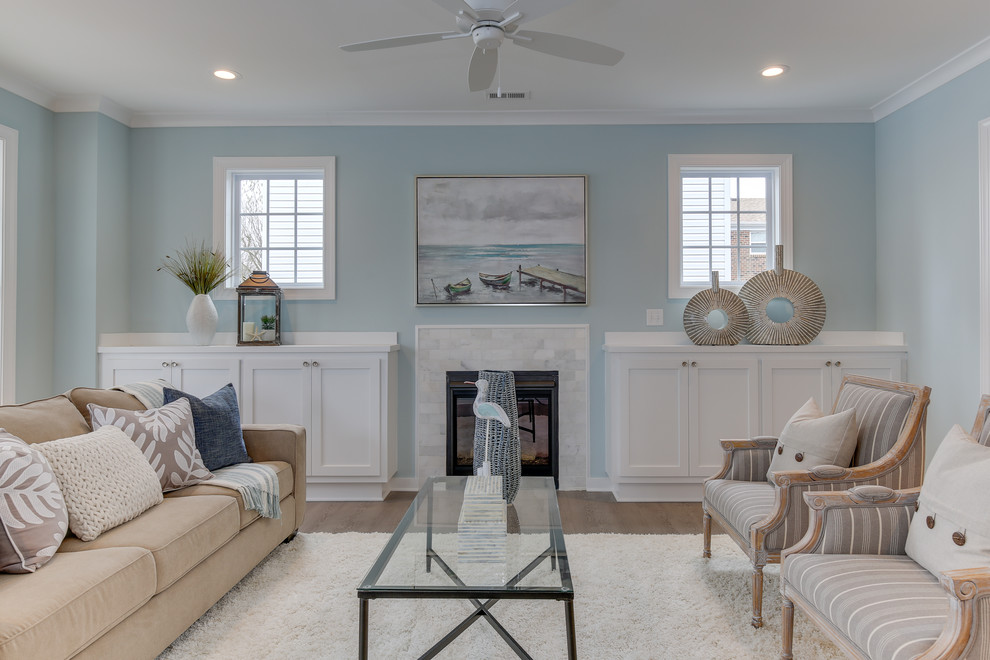 Идея дизайна: открытая гостиная комната среднего размера в морском стиле с синими стенами, светлым паркетным полом, стандартным камином, фасадом камина из плитки, отдельно стоящим телевизором и серым полом
