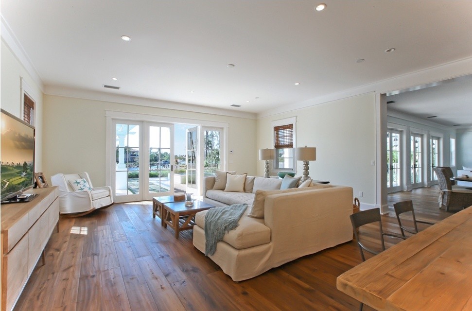 Photo of a large nautical open plan games room in Miami with beige walls, dark hardwood flooring and a freestanding tv.