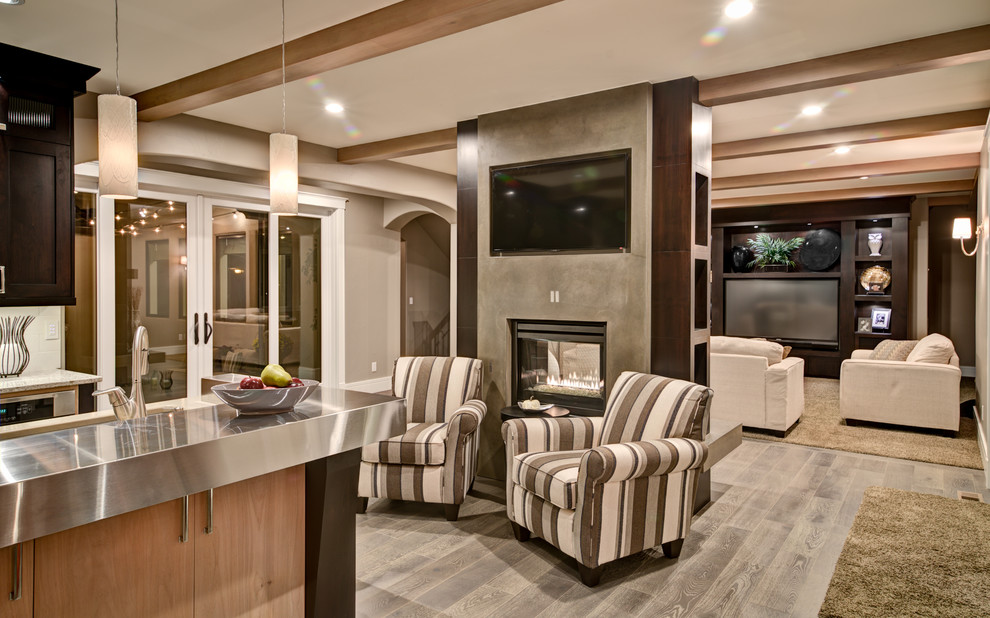 Modelo de sala de estar abierta moderna de tamaño medio con paredes beige, suelo de madera en tonos medios, chimenea de doble cara, marco de chimenea de hormigón, pared multimedia y suelo gris