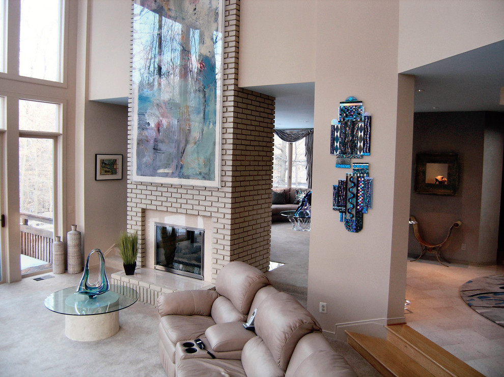 Imagen de sala de estar abierta contemporánea grande con paredes beige, moqueta, chimenea de doble cara, marco de chimenea de ladrillo y suelo beige