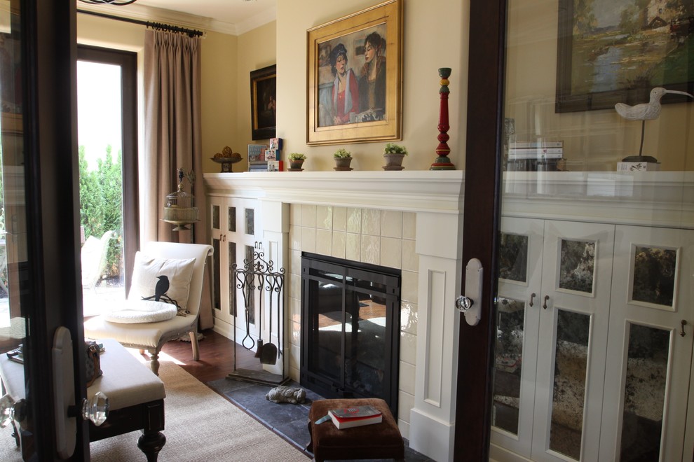 Пример оригинального дизайна: огромная открытая гостиная комната в современном стиле с фасадом камина из плитки, с книжными шкафами и полками, стандартным камином и телевизором на стене