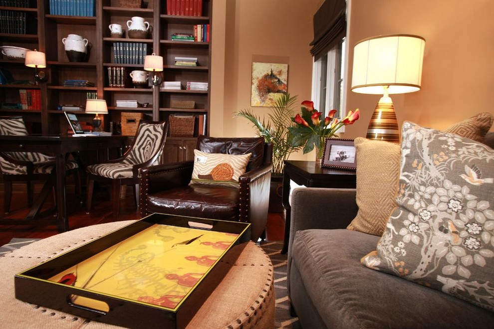 Imagen de sala de estar con biblioteca cerrada actual de tamaño medio sin chimenea y televisor con parades naranjas y suelo de madera en tonos medios
