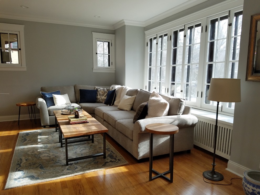 Mittelgroßes, Offenes Modernes Wohnzimmer ohne Kamin mit grauer Wandfarbe, hellem Holzboden, TV-Wand und beigem Boden in Chicago