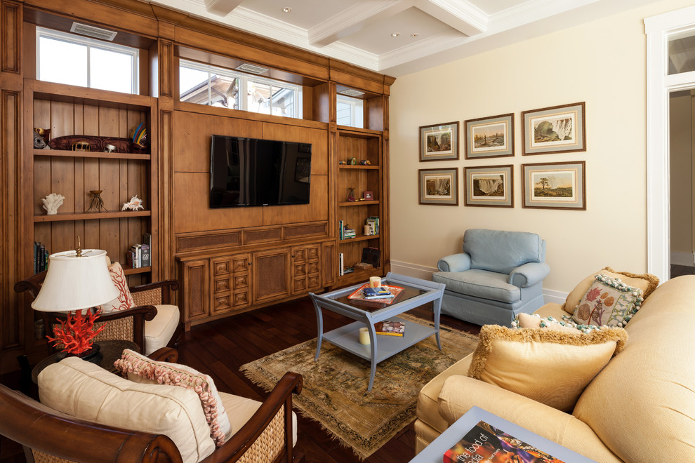 Foto de sala de estar tradicional con paredes beige, suelo de madera oscura y pared multimedia