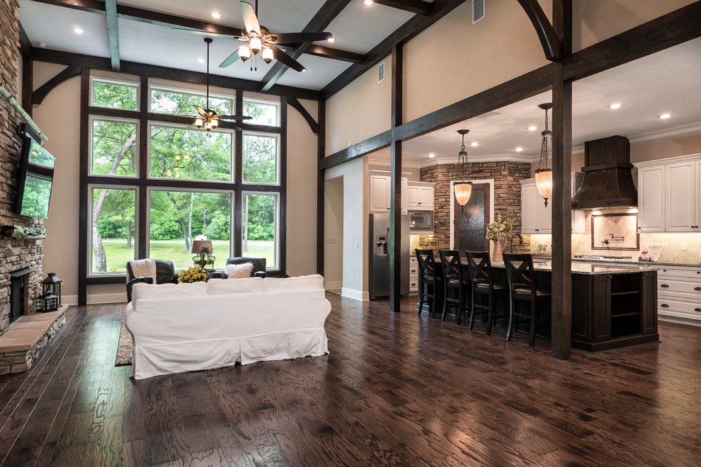 Large arts and crafts open concept dark wood floor family room photo in Miami with black walls, a standard fireplace, a stone fireplace and a wall-mounted tv