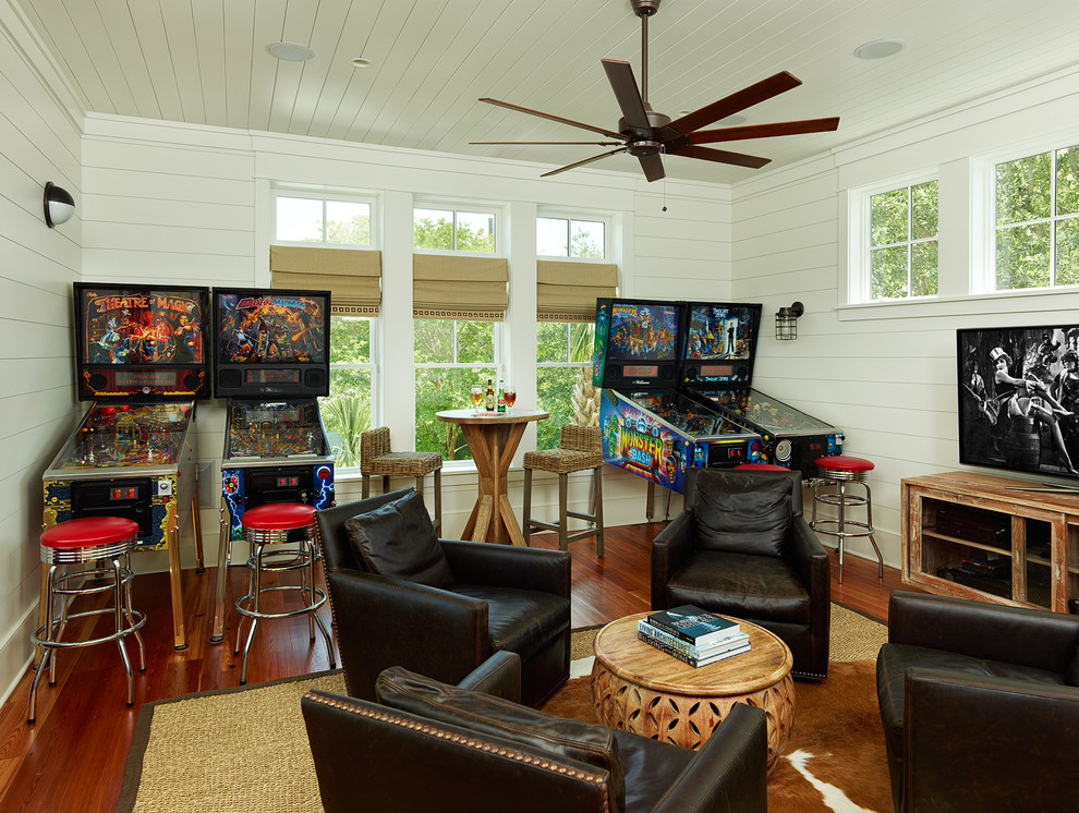 Ejemplo de sala de juegos en casa exótica con paredes blancas, suelo de madera oscura y televisor independiente
