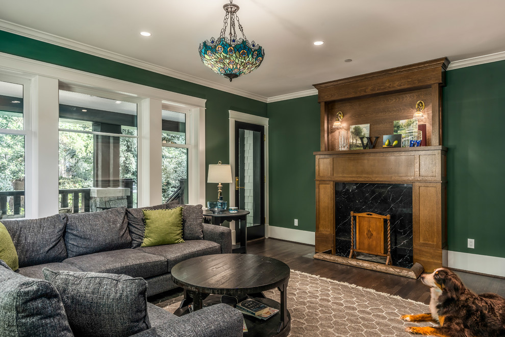 Immagine di un grande soggiorno classico chiuso con pareti verdi, parquet scuro, camino classico, cornice del camino in legno e pavimento marrone