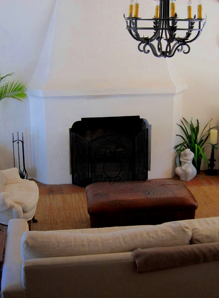 Photo of a medium sized mediterranean enclosed games room in Santa Barbara with white walls, terracotta flooring, a standard fireplace, a concrete fireplace surround and red floors.