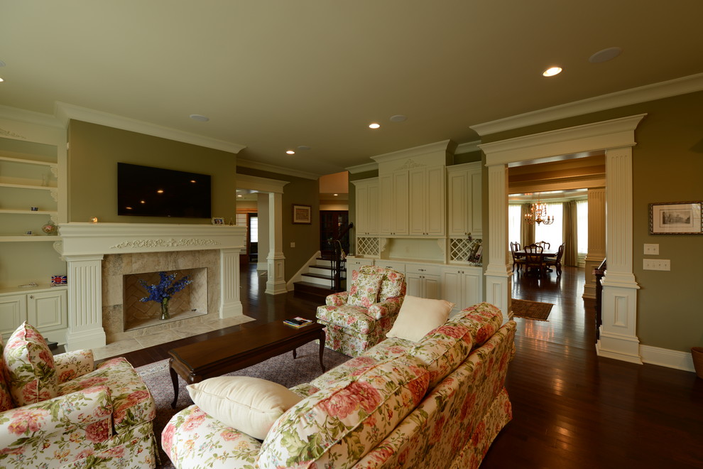 This is an example of a medium sized traditional open plan games room in Indianapolis with green walls, dark hardwood flooring, a standard fireplace, a wooden fireplace surround and a wall mounted tv.