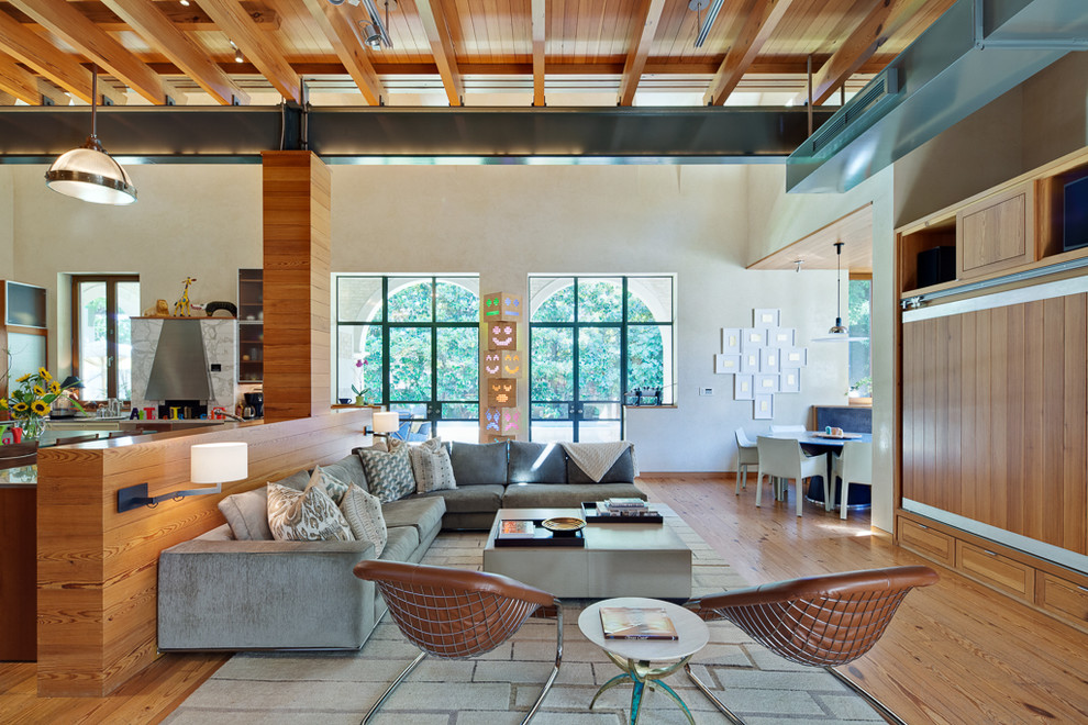 Foto di un soggiorno minimal aperto con pareti beige, pavimento in legno massello medio e TV nascosta