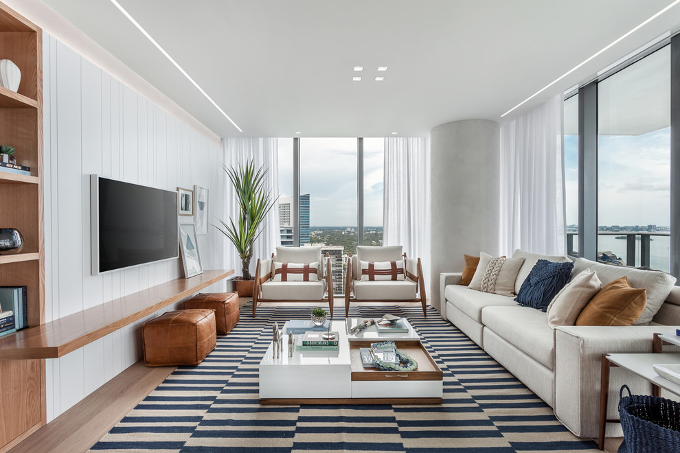 Großes, Offenes Maritimes Wohnzimmer ohne Kamin mit weißer Wandfarbe, TV-Wand und hellem Holzboden in Miami