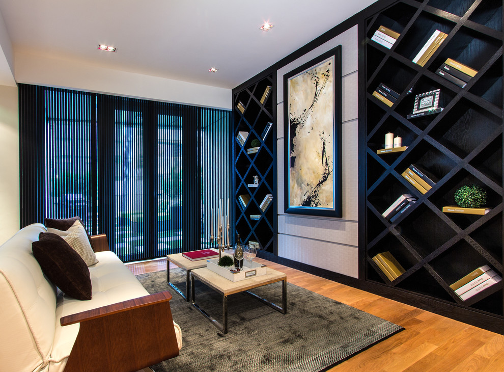Immagine di un soggiorno design con libreria, pareti beige e parquet chiaro