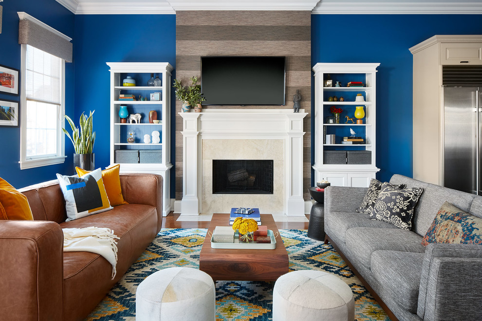 シカゴにあるエクレクティックスタイルのおしゃれなオープンリビング (青い壁、無垢フローリング、標準型暖炉、石材の暖炉まわり、壁掛け型テレビ、茶色い床) の写真