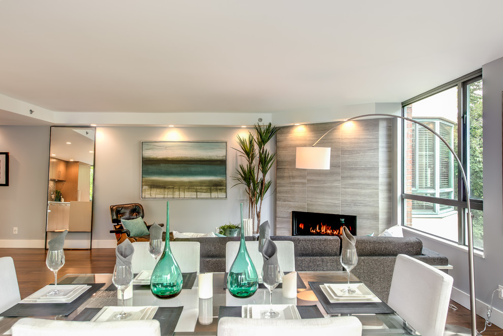 Diseño de sala de estar abierta clásica renovada de tamaño medio sin televisor con paredes azules, suelo de madera en tonos medios, chimenea de esquina y marco de chimenea de baldosas y/o azulejos