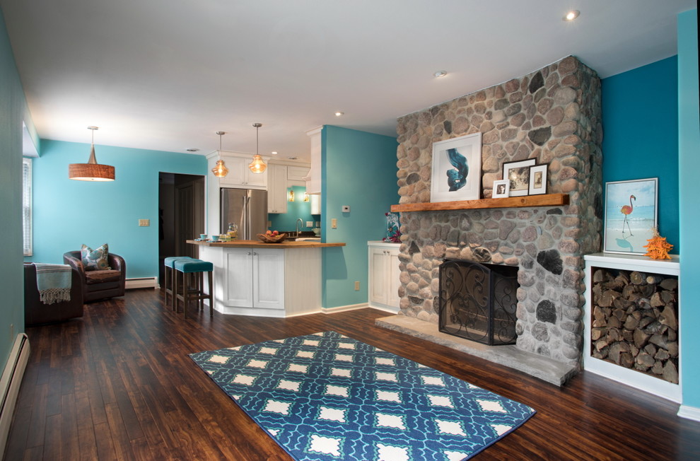 Свежая идея для дизайна: открытая гостиная комната среднего размера в морском стиле с синими стенами, полом из винила, стандартным камином, фасадом камина из камня, телевизором на стене и коричневым полом - отличное фото интерьера