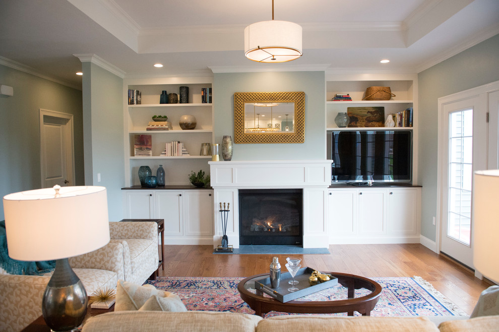 Geräumiges Klassisches Wohnzimmer mit blauer Wandfarbe, braunem Holzboden, Kamin, gefliester Kaminumrandung, Multimediawand und braunem Boden in Boston