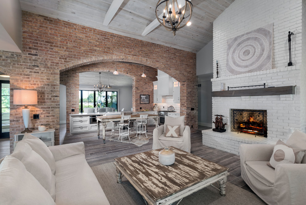 Inspiration for a medium sized beach style open plan games room in Detroit with beige walls, ceramic flooring, a standard fireplace, a brick fireplace surround, no tv and grey floors.