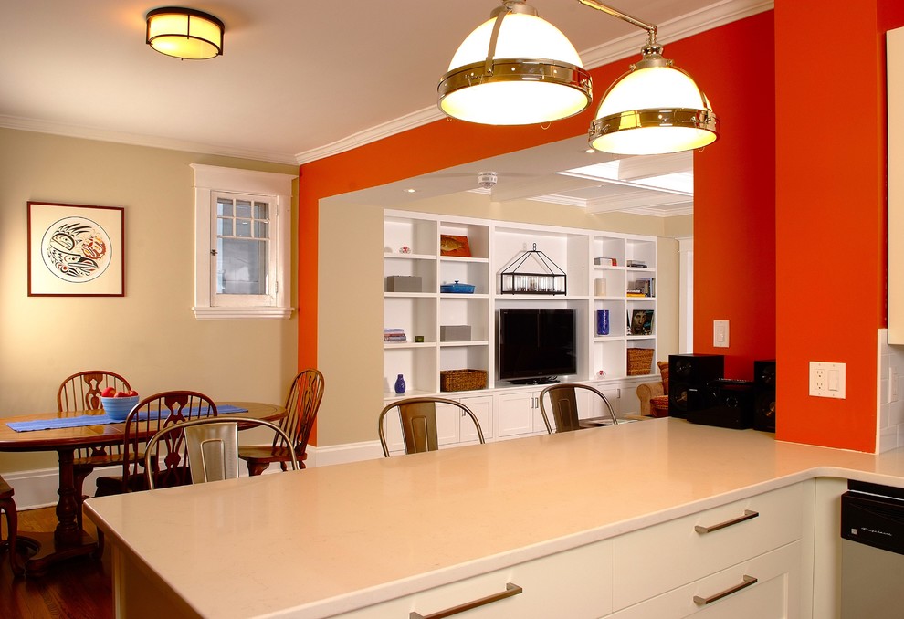 Réalisation d'une grande salle de séjour tradition ouverte avec un mur orange et parquet foncé.