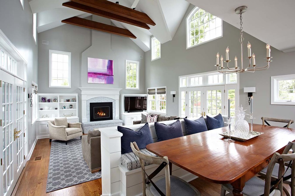 Example of a transitional medium tone wood floor family room design in New York with a standard fireplace and a brick fireplace