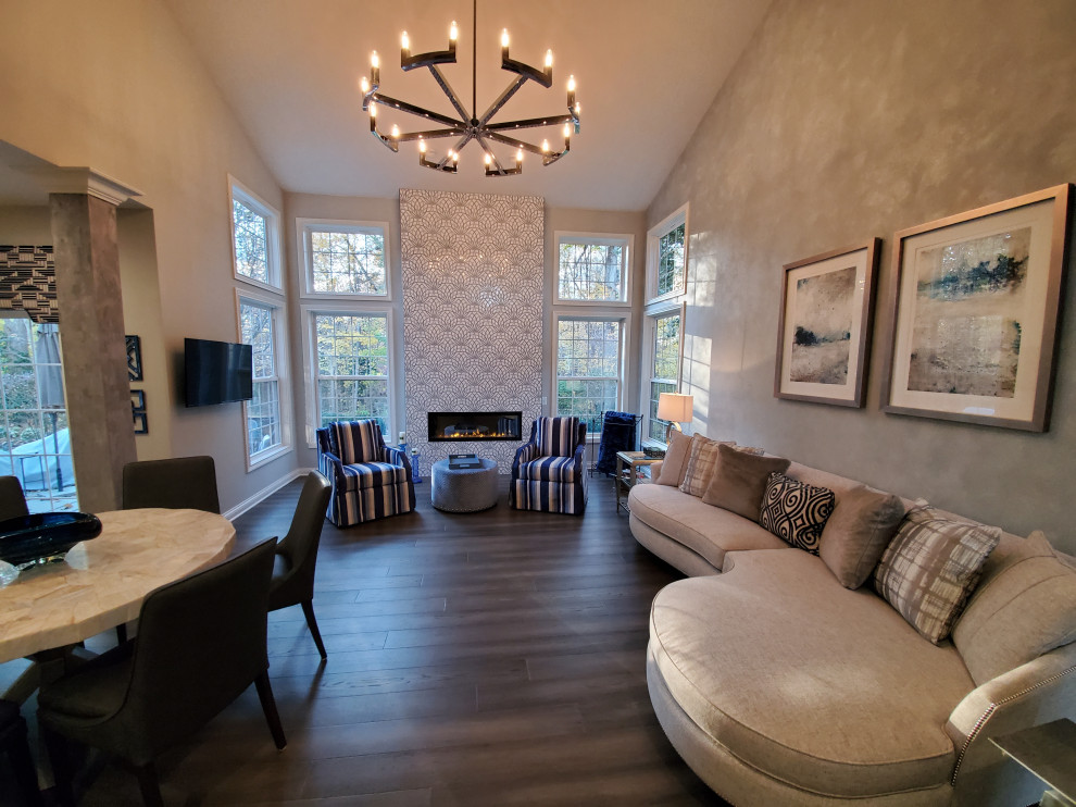 Cette image montre une salle de séjour traditionnelle de taille moyenne et ouverte avec un mur gris, un sol en bois brun, une cheminée standard, un manteau de cheminée en carrelage et un sol gris.