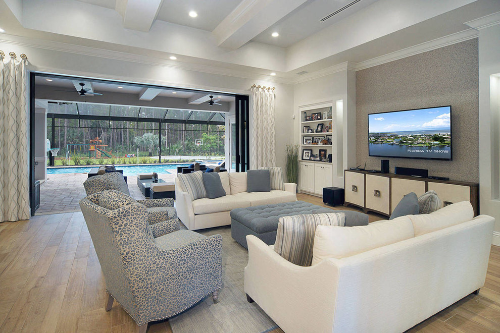 Idee per un grande soggiorno design aperto con pareti grigie, parquet chiaro, TV a parete e pavimento beige