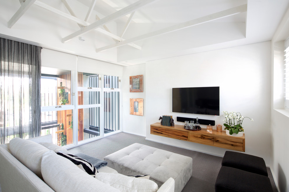 Immagine di un grande soggiorno minimalista con pareti bianche, moquette e parete attrezzata
