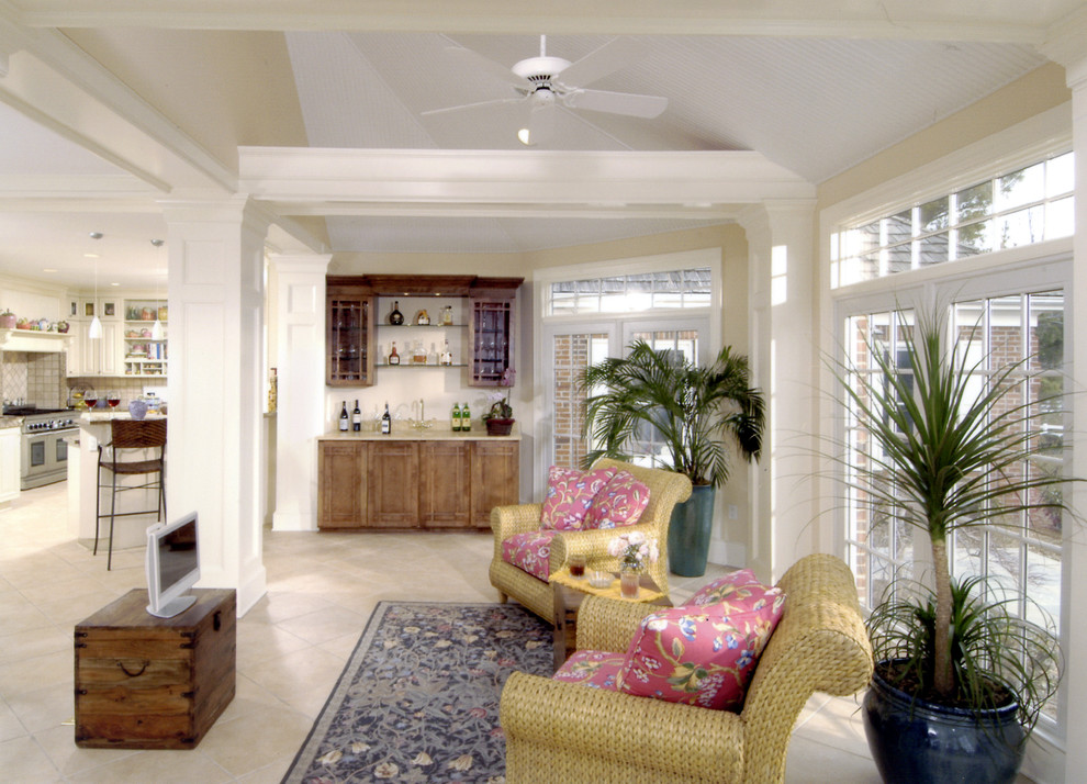 Modelo de sala de estar con barra de bar abierta tradicional con paredes beige, suelo de baldosas de cerámica y televisor independiente