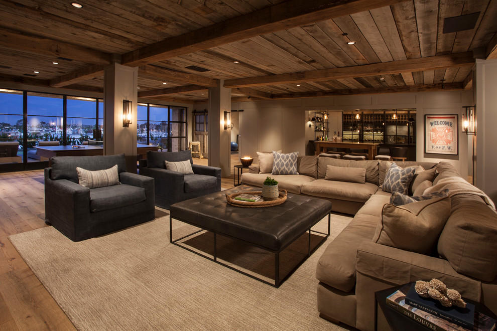Aménagement d'une très grande salle de séjour contemporaine ouverte avec un bar de salon, un mur beige et un sol en bois brun.