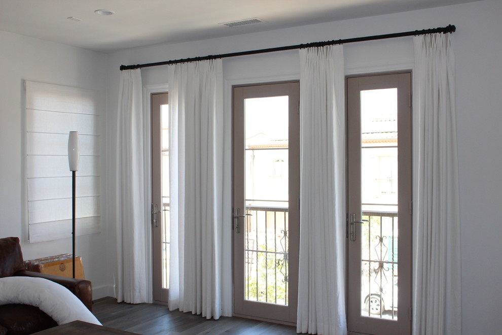 Imagen de sala de estar abierta contemporánea sin chimenea con paredes blancas y suelo de madera oscura
