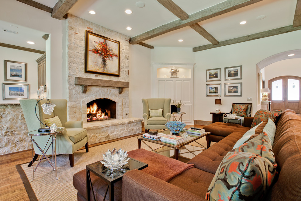Diseño de sala de estar contemporánea con paredes beige, suelo de madera en tonos medios, todas las chimeneas y marco de chimenea de piedra