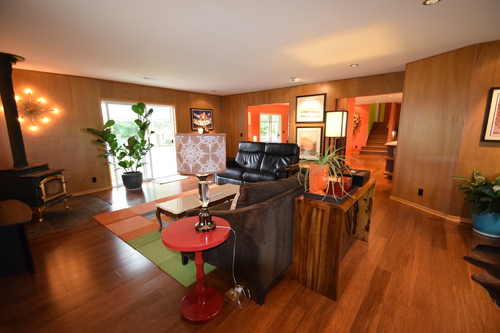 Стильный дизайн: большая изолированная гостиная комната в стиле ретро с коричневыми стенами, полом из бамбука, печью-буржуйкой, фасадом камина из камня и коричневым полом - последний тренд