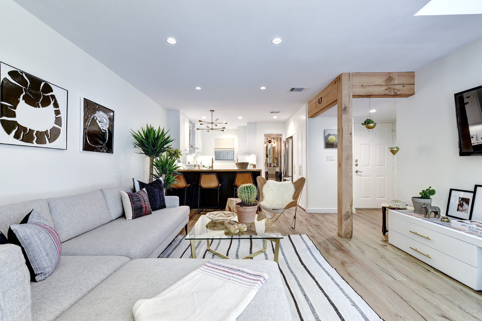 Foto di un grande soggiorno classico aperto con pareti bianche, parquet chiaro e TV a parete