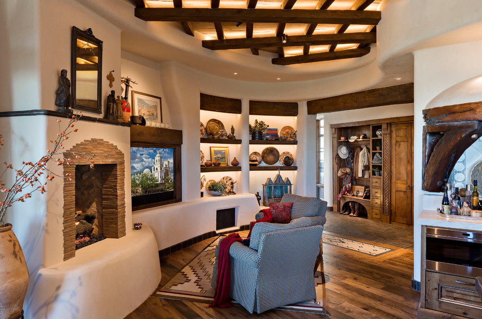 Großes, Offenes Mediterranes Wohnzimmer mit beiger Wandfarbe, Multimediawand, braunem Boden, braunem Holzboden, Kamin und Kaminumrandung aus Stein in Phoenix