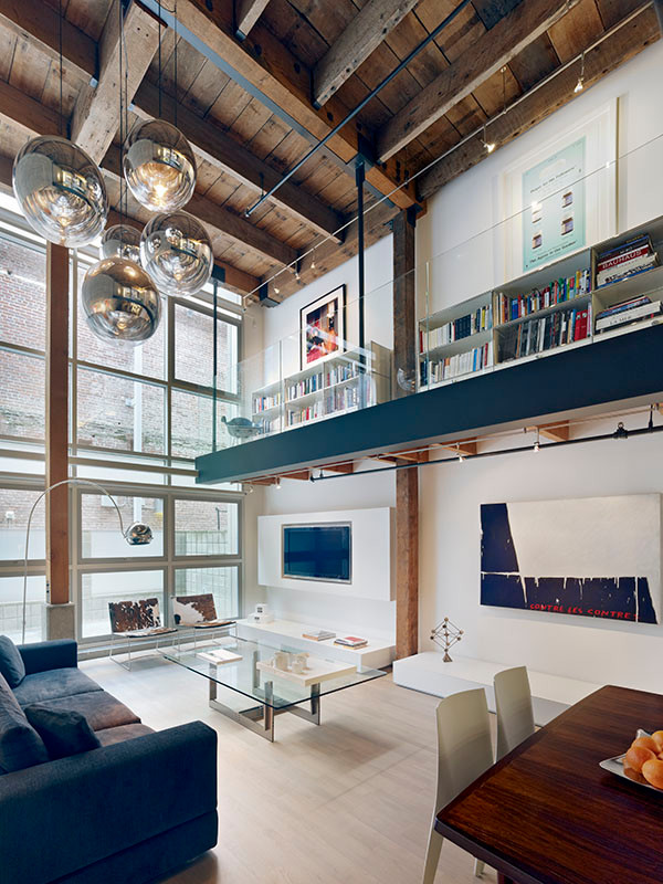 Inspiration pour une salle de séjour mansardée ou avec mezzanine urbaine de taille moyenne avec un mur blanc, parquet clair, un téléviseur encastré et une bibliothèque ou un coin lecture.