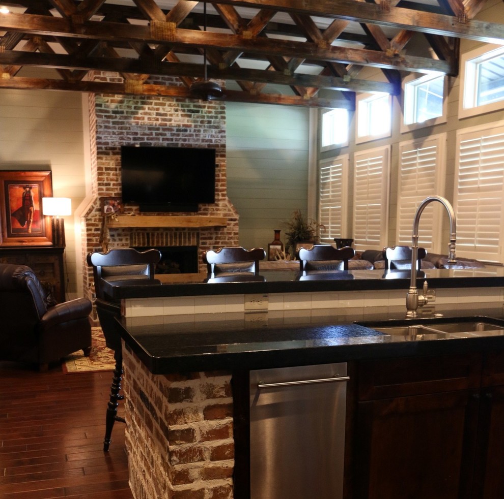 Example of a large urban open concept medium tone wood floor family room design in Houston with green walls, a standard fireplace, a brick fireplace and a wall-mounted tv