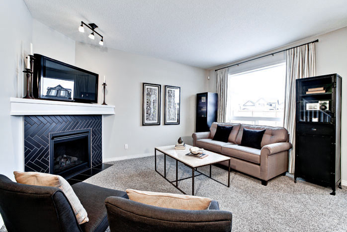 Family room - mid-sized eclectic open concept carpeted family room idea in Calgary with gray walls, a standard fireplace, a tile fireplace and a tv stand