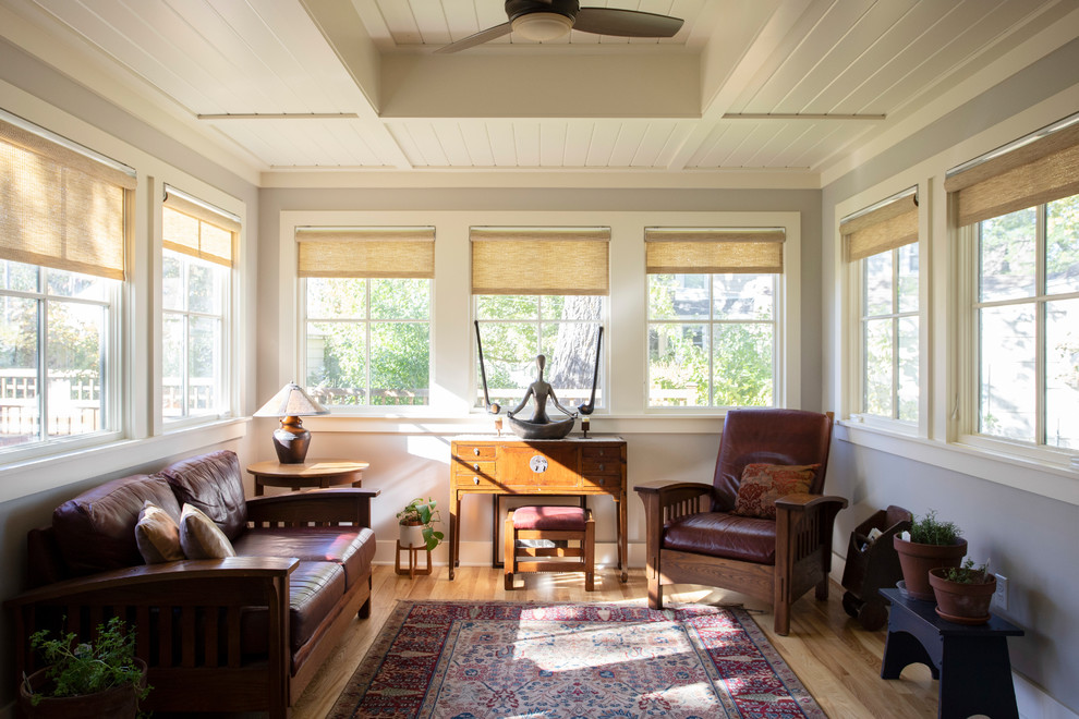 Imagen de sala de estar cerrada de estilo de casa de campo de tamaño medio sin chimenea y televisor con paredes grises, suelo de madera clara y suelo marrón