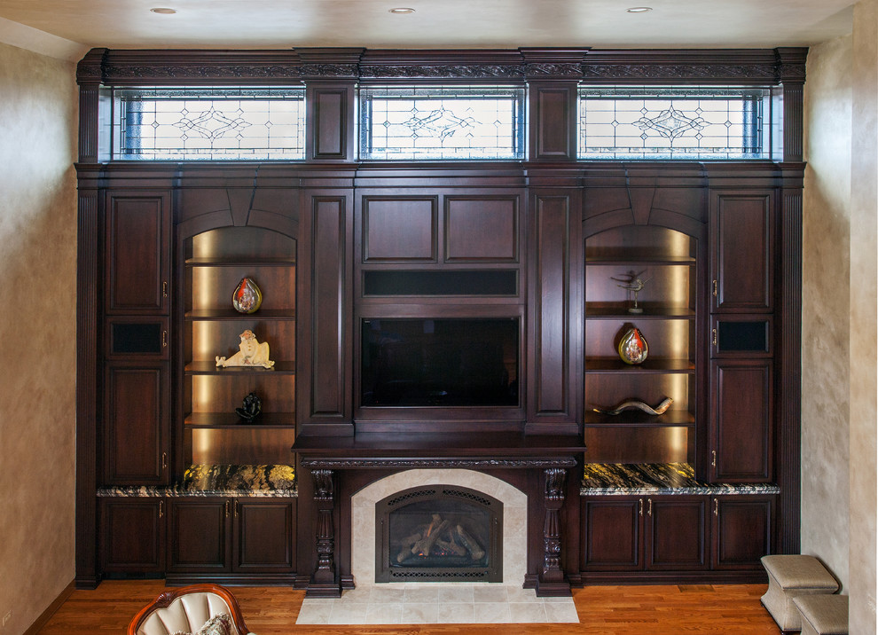 Photo of a large classic enclosed games room in Chicago with beige walls, medium hardwood flooring, a standard fireplace, a stone fireplace surround and a built-in media unit.