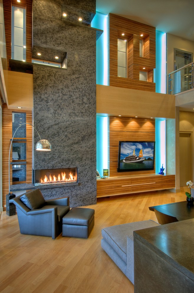 Inspiration for a large contemporary open plan games room in Tampa with grey walls, medium hardwood flooring, a stone fireplace surround, a wall mounted tv and a ribbon fireplace.