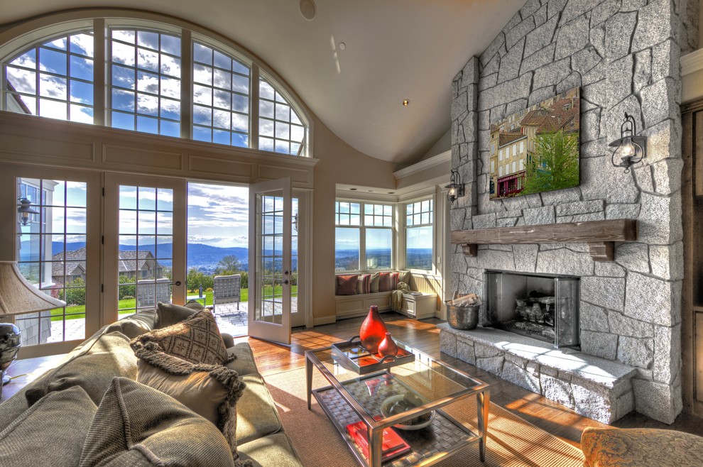Modernes Wohnzimmer mit beiger Wandfarbe, braunem Holzboden, Kamin und Kaminumrandung aus Stein in Seattle