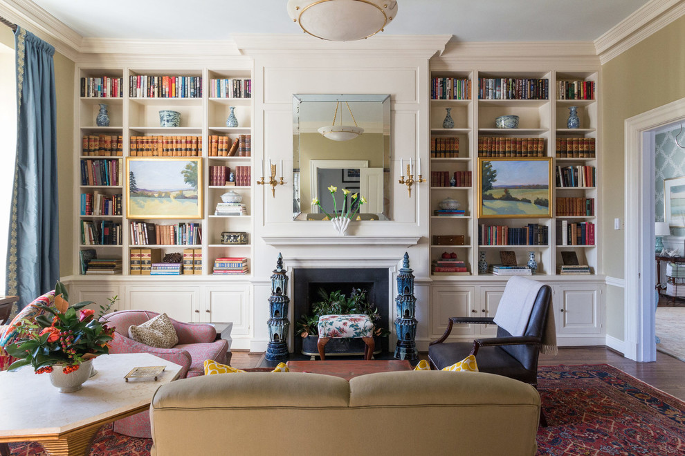 Cette image montre une salle de séjour traditionnelle fermée et de taille moyenne avec une bibliothèque ou un coin lecture, un mur beige, une cheminée standard, parquet foncé et un manteau de cheminée en carrelage.