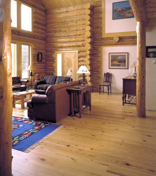 Diseño de sala de estar abierta rústica grande sin chimenea y televisor con paredes blancas y suelo de madera en tonos medios