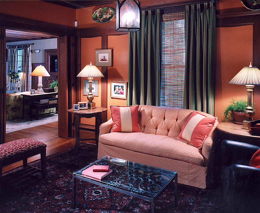 Cette photo montre une salle de séjour tendance de taille moyenne et ouverte avec un mur orange, parquet foncé, aucune cheminée et un sol marron.